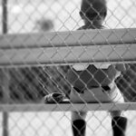 Young Baseball Player Waiting on Sidelines