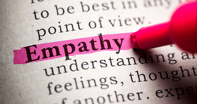 A dictionary page with the word "empathy" and its definition. The word "empathy" is being highlighted with a pink marker.