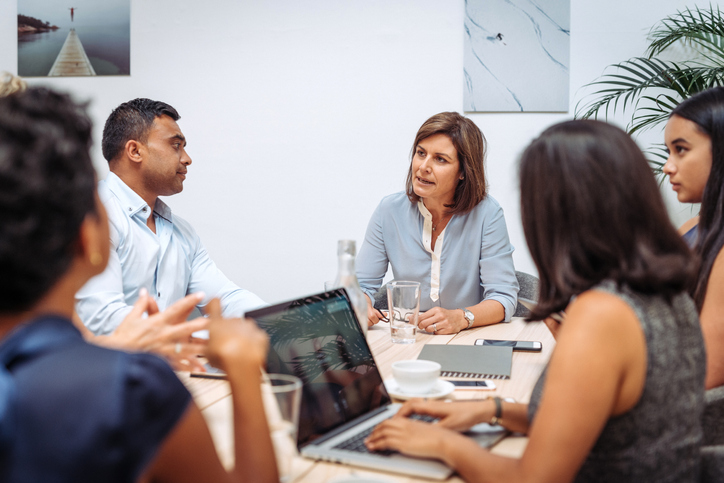 Manager talking to her employees in the office at the formal meeting