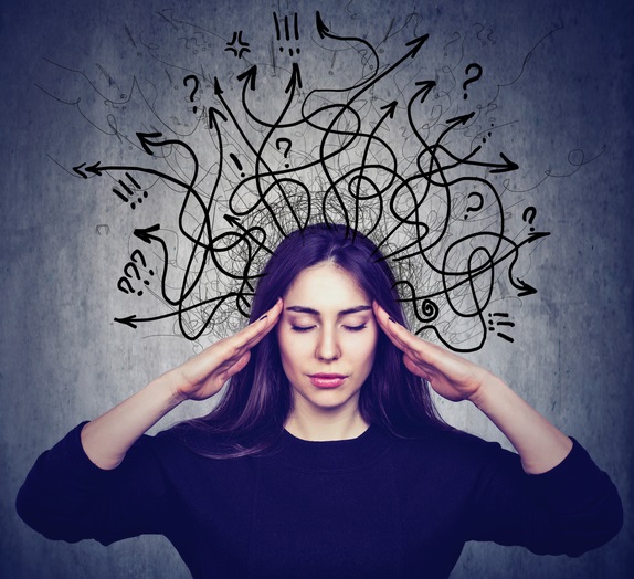 Picture of a woman with her eyes closed and hands at her temples trying to control her thoughts. There are lots of squiggly lines with arrows and different icons to display an array of thoughts