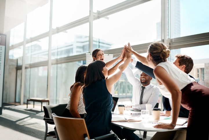 A group of people in an office high-fiving