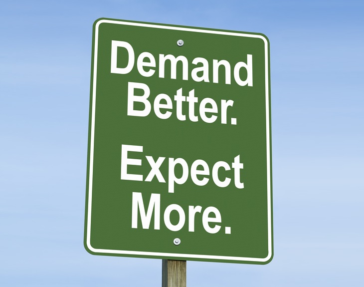 A green sign with white letters that says "Demand Better. Expect More."