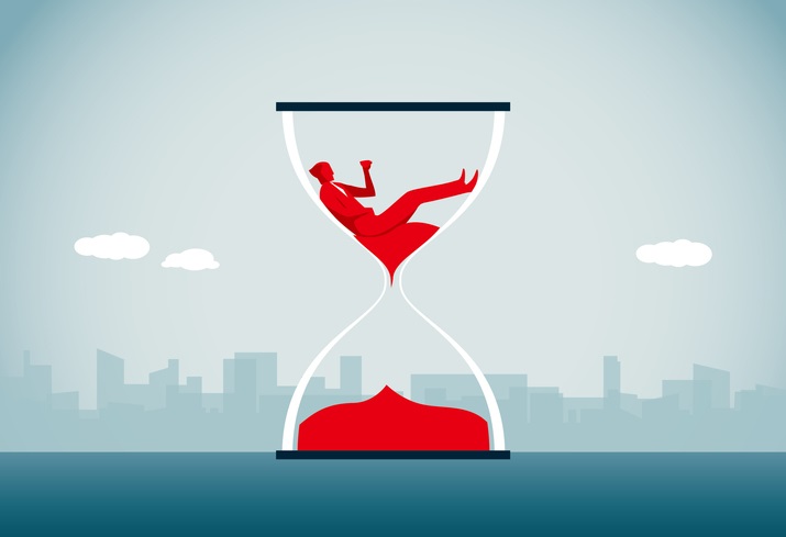 A drawing of an hourglass with red sand in the bottom half and the red shape of a man sitting on red sand in the top half