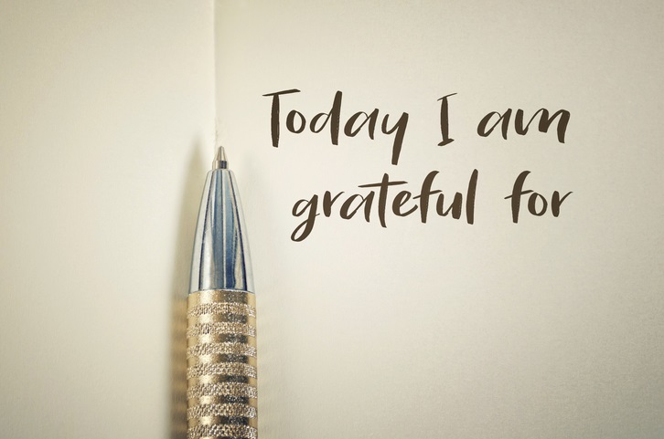 A picture of an open journal with a pen and "today I am grateful for" written on the page