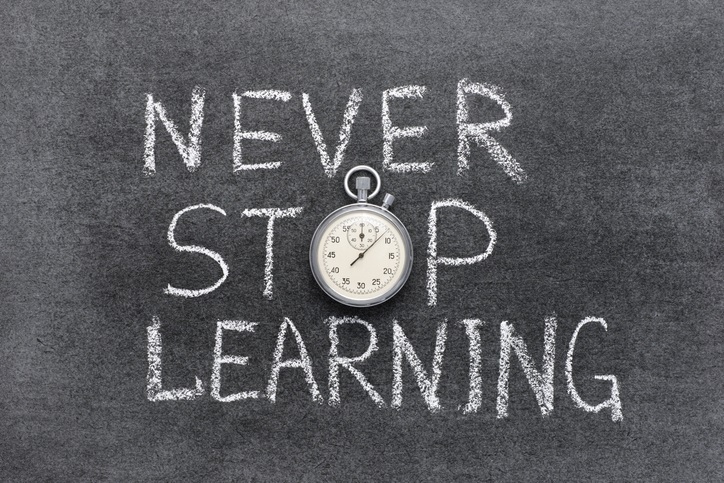 The words "never stop learning" written on a chalkboard. the "o" in "stop" is a stopwatch
