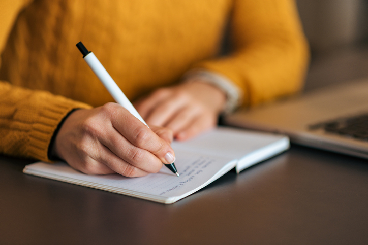 Photo of a woman writing in a journal