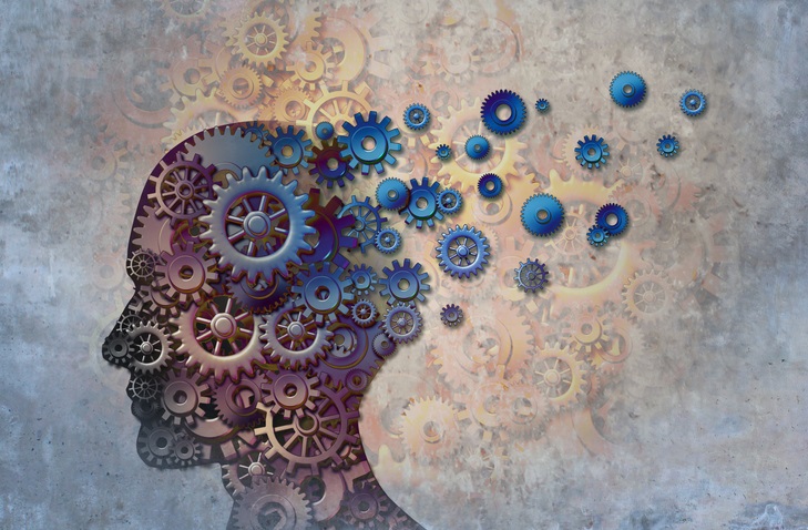 Silhouette of a human head in side profile, made up of gears, with some of the gears floating out from the back of the head